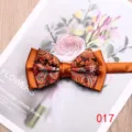 Close-up detail of a stylish orange paisley bow tie with elegant two-tone satin contrast. - 017