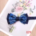 Close-up of elegant blue patterned men's bow tie on floral background card detail view - Style 029