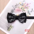 Close-up detail of a classic black patterned bow tie with double layer design for formal wear. - Color 032
