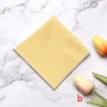 Nahaufnahme eines gelben Herren-Einstecktuchs mit feiner Waffelstruktur auf Marmor. - Gelb