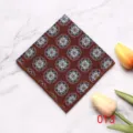 Gedetailleerde close-up van een bruine herenpochet met blauw-witte bloemmotieven voor formele pakken. - 013