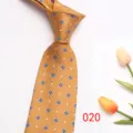 Close up of gold men tie with blue clover jacquard pattern and tulip flower prop detail. - Color 020