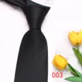 Detail view of a black business men's tie on marble background with tulip decor. - Color 003