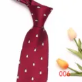 Primo piano dell'elegante cravatta da uomo bordeaux con piccoli motivi di pinguini. - Colore 006