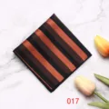 Gedetailleerd uitzicht van het zwart-bronzen gestreepte pochet op marmer met tulpenbloem. - 017