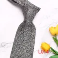 Detail view of a black and white patterned men's necktie featuring an elegant floral design. - Black and White Floral (L014)