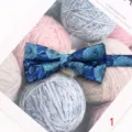 Primer plano detallado de una elegante pajarita para hombre con motivo floral azul. - Estilo 1