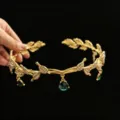 Primer plano detallado de una tiara dorada estilo bosque con hojas y gemas verdes de gota - Colgante de Frente Imitación Oro Verde