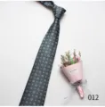 Detailed view of the men's dark geometric patterned necktie with elegant dried flower decor. - 012