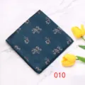 Gedetailleerd overzicht van een donkerblauwe geruite herenpochet met verfijnd bloemenmotief. - 010