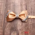 Primo piano di un elegante papillon in raso dorato con decorazioni in strass brillanti. - Oro (002)
