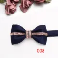 Primo piano dettagliato di un farfallino in raso blu scuro con strass rosa e cristalli. - Blu scuro