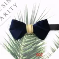 Close-up detail of dark blue velvet bow tie with gold center stripe for formal suit. - Dark Blue