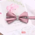 Dettaglio in primo piano di un elegante papillon in raso rosa con strass su sfondo floreale. - Rosa