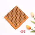 Detailopname van een klassieke oranje pochette met kleine blauwe bloemmotieven, ideaal pakaccessoire. - 002