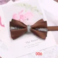 Primo piano del papillon in raso marrone con strass scintillanti e raffinato design a doppio strato. - Marrone