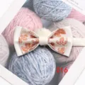 Vue détaillée d'un nœud papillon double blanc élégant avec motif de feuilles orange pour costume. - Couleur 016