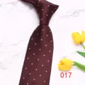 Primo piano dettaglio cravatta uomo bordeaux a pois su marmo con decorazioni di tulipani gialli. - 017