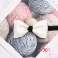 Gedetailleerd overzicht van een klassieke witte herenvlinderdas met zwarte knoop. - 001 Stijl