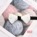 Gedetailleerd overzicht van een stijlvolle witte herenstrik met zwarte knoop voor formele kostuums. - Stijl 002