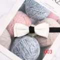 Detailopname van de elegante witte dubbele vlinderdas met zwarte knoop voor formele pakken. - Stijl 003