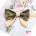 Primer plano de una pajarita elegante de hombre con motivo floral dorado y raso champán. - Color 002
