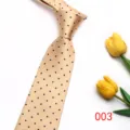 Primer plano detallado de una corbata color champán con elegantes lunares azul oscuro. - Color 003