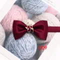 Dettaglio papillon in seta rosso vino con delicato ciondolo in metallo a foglia d'oro casual. - Borgogna