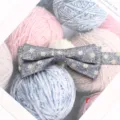 Gros plan détaillé d'un nœud papillon en tissu gris double couche élégant et chic. - Style R