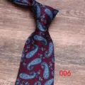 Close-up of a burgundy necktie with elegant blue paisley patterns for formal events. - Color 006