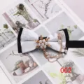 Vista dettagliata elegante del papillon bianco con centro di perle e catenelle pendenti. - Stile 002