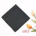Vista de detalle cercana del elegante pañuelo de bolsillo con patrón de cuadros y lunares rojos. - L012