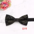 Detailed view of elegant black bow tie with gold flecked pattern on marble background for men. - Color 019