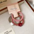 Close-up detail shot of cute heart pendant spiral hair ties set with branded packaging card. - Pink