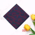 Detailed shot of a stylish dark blue pocket square featuring an elegant red feather print pattern. - Color 007