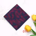Detailed shot of men's polyester pocket square featuring vibrant red feather pattern on navy. - Color 011