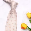 Detail view of light pink men's floral woven necktie on white marble with yellow tulips. - Light Small Floral (007)