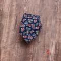Close-up detail van een donkerblauwe herenstropdas met klassiek paisleypatroon. - Stijl 5