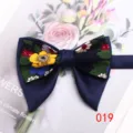 Dettaglio del farfallino floreale vintage a doppio corno con tessuto blu e fiori colorati. - Colore 019
