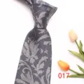 Detailed close-up view of a stylish grey men's tie featuring an elegant silver floral jacquard. - 017 (Gray Floral)