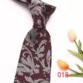 Detailed view of a classy burgundy men's tie featuring intricate silver leaf jacquard patterns. - 018 (Burgundy Leaf Pattern)