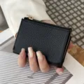 Kompakte schwarze Damen Geldbörse aus Leder im dreifach gefalteten Design mit Münzfach. - Schwarz