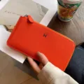 Oranger Damen Geldbörse aus Leder mit elegantem Metall H Verschluss und Reissverschluss. - Orange
