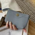 Grey leather coin purse with zipper, keychain, and elegant floral metal clasp design. - Light Blue