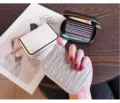 Close-up detail of compact multi-slot zippered leather card holder with quilted texture. - Gray