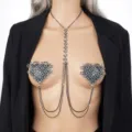 Detailed shot of rhinestone heart pasties and layered body chain fashion accessory. - Black