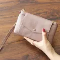 Minimalistische Leder-Clutch für Damen, stilvolle Handytasche mit Handschlaufe und Druckknopf. - Rosa