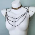 Close-up detail of dark gothic multi-layered body chain and gem choker necklace jewelry. - Black & Gold
