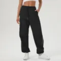 Pantalón deportivo negro con bandas laterales blancas, corte recto holgado y cintura con cordón. - S / Negro