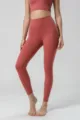 Vista detallada del pantalón de yoga de talle alto con bolsillo lateral y tela suave para entrenar. - Rojo Purpúreo